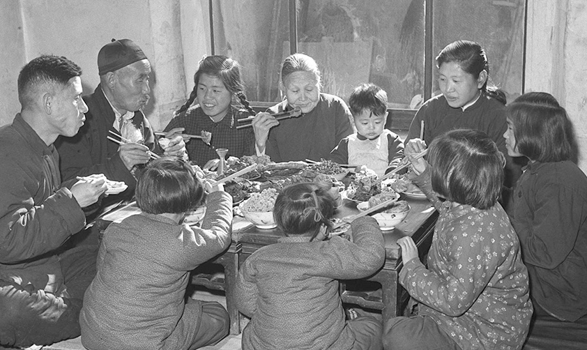 1953年春节天津汉沽区芦台王德铸(左一)一家人吃团圆饭（新华社稿）